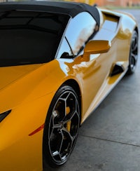 a yellow sports car is parked in a garage